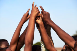 About closeup shot of a group of young boys joining their hands together in a huddle.